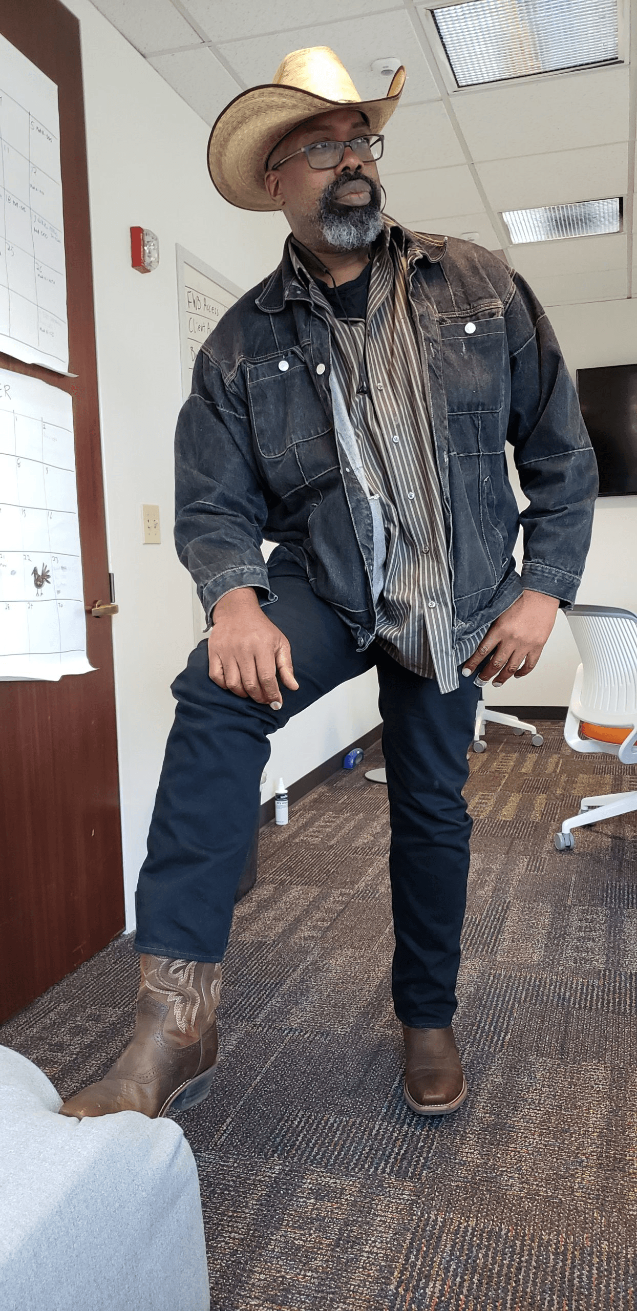 Louis Alston in a straw cowboy hat and denim jacket, in the All Stone Tech office